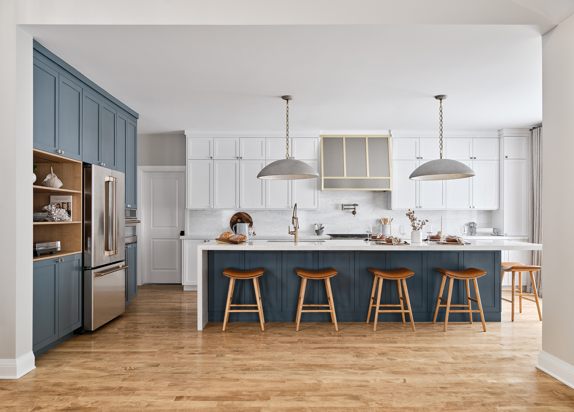 A kitchen with blue cabinets and stools
