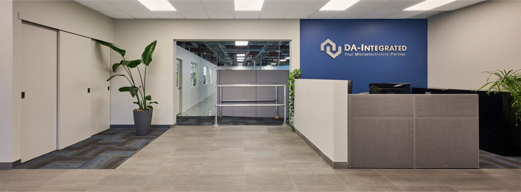 A sleek corporate front desk area featuring a large blue-branded wall and office cubicles