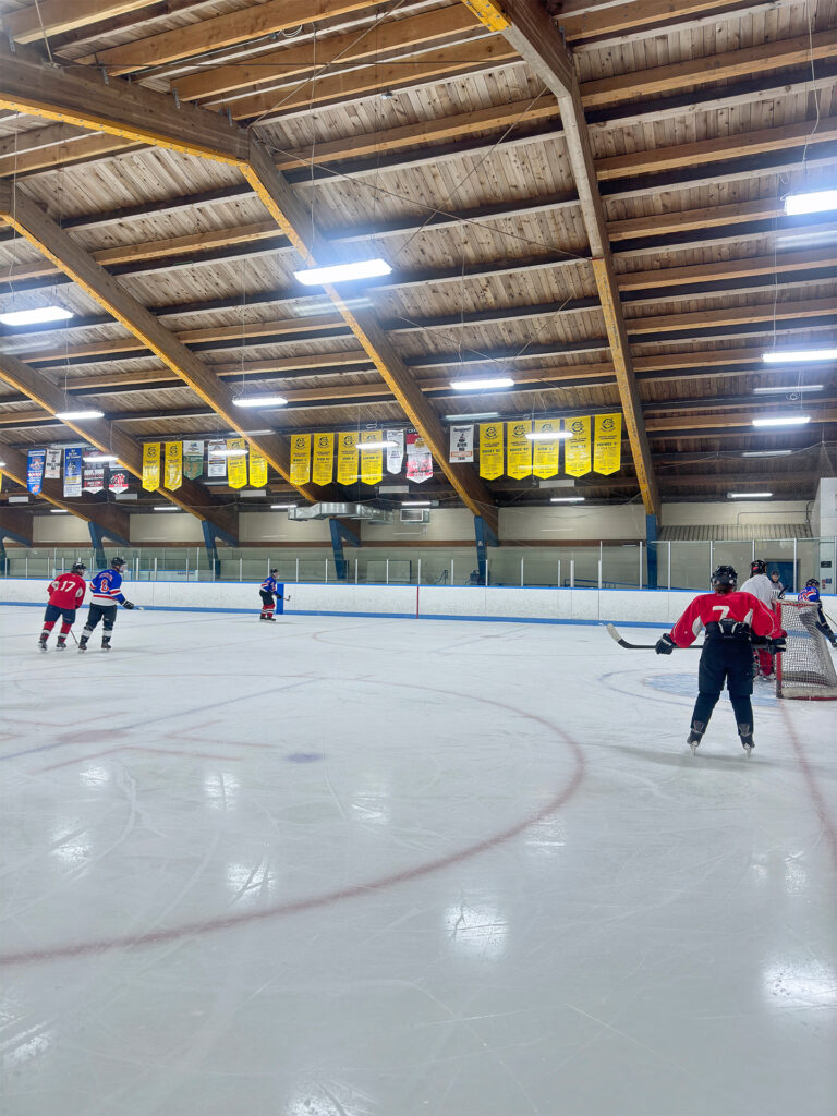 Indoor ice hockey arena with wooden beams on the ceiling