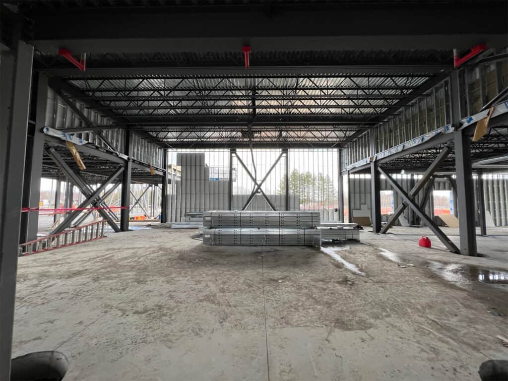 ChatGPT Interior of a construction site with a metal framework, stacked materials on the floor