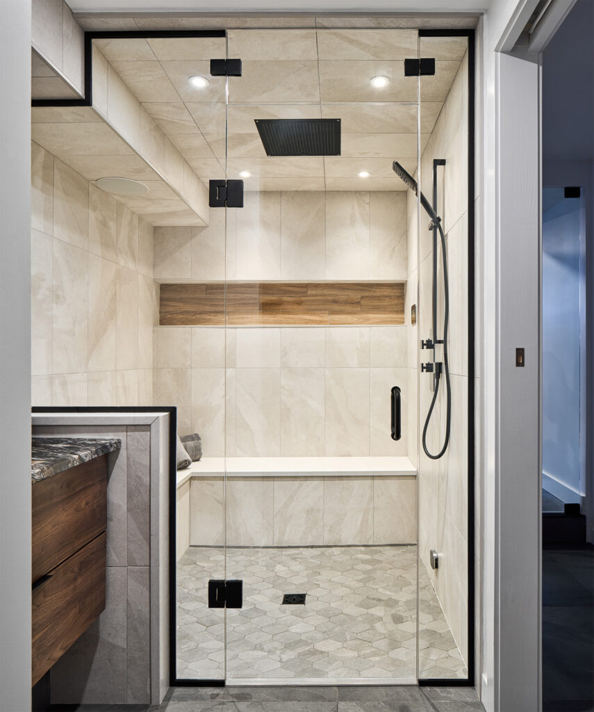 Elegant bathroom showcasing a spacious walk-in shower with beige tiles, wood accents, and modern black fixtures